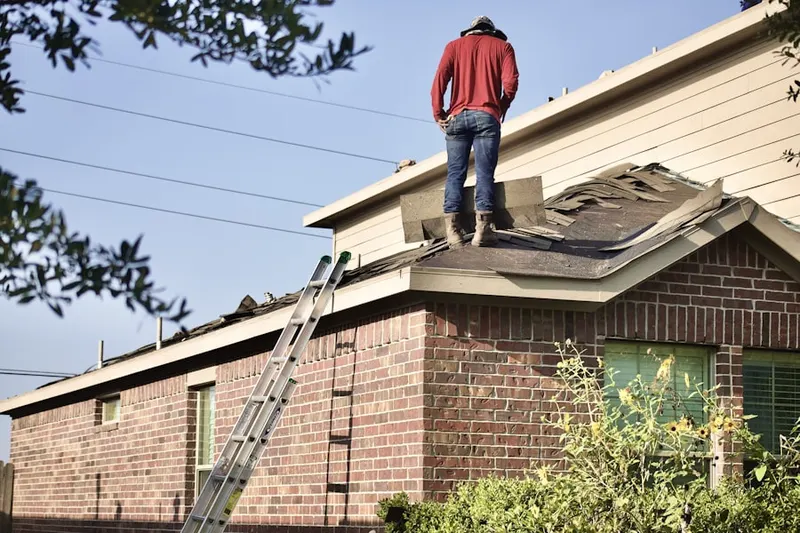 Professional roofer working on a residential roof in Riverside Park